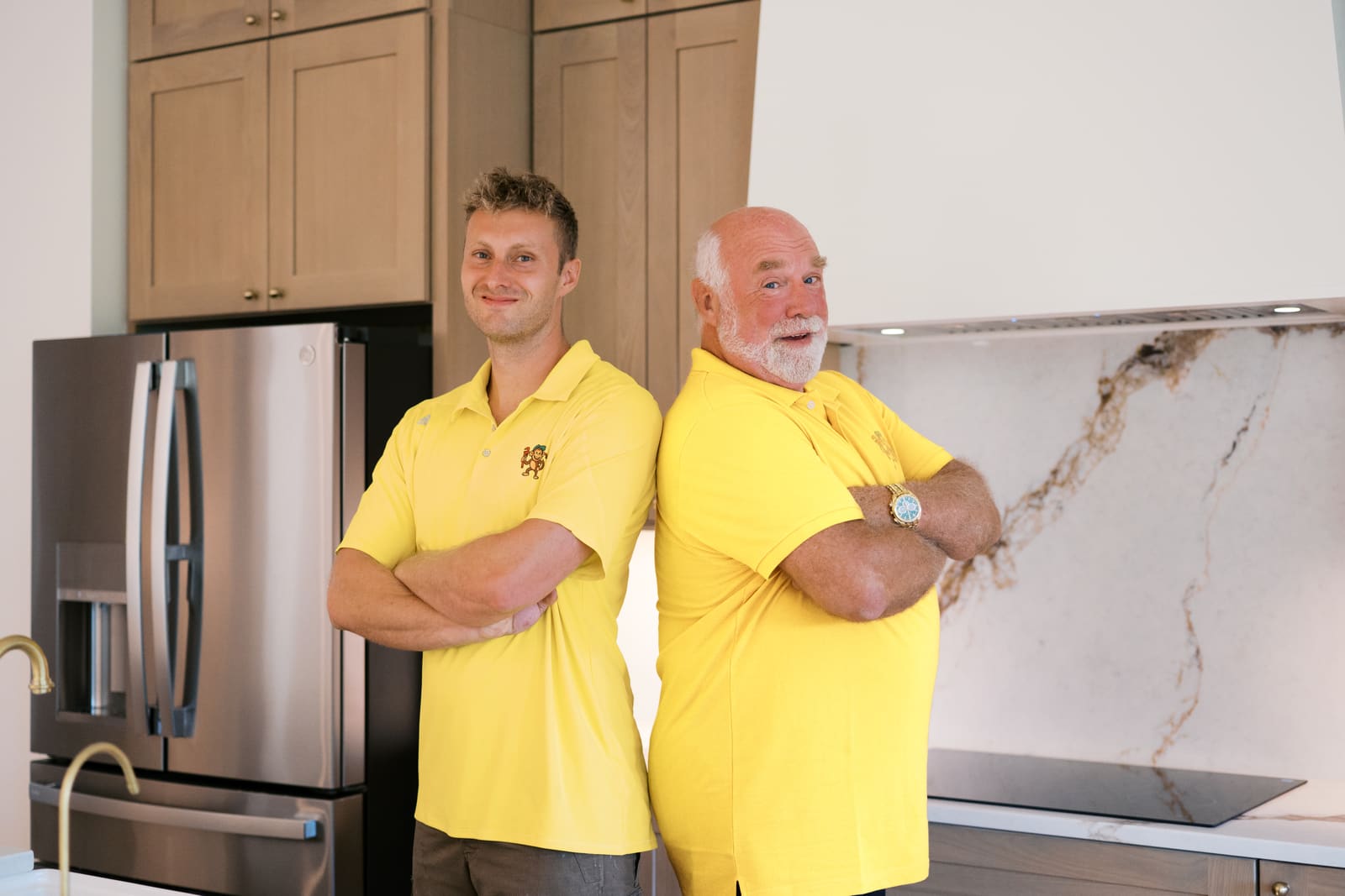 Josh and Pat of Rapid Water Heater in yellow shirts, arms crossed