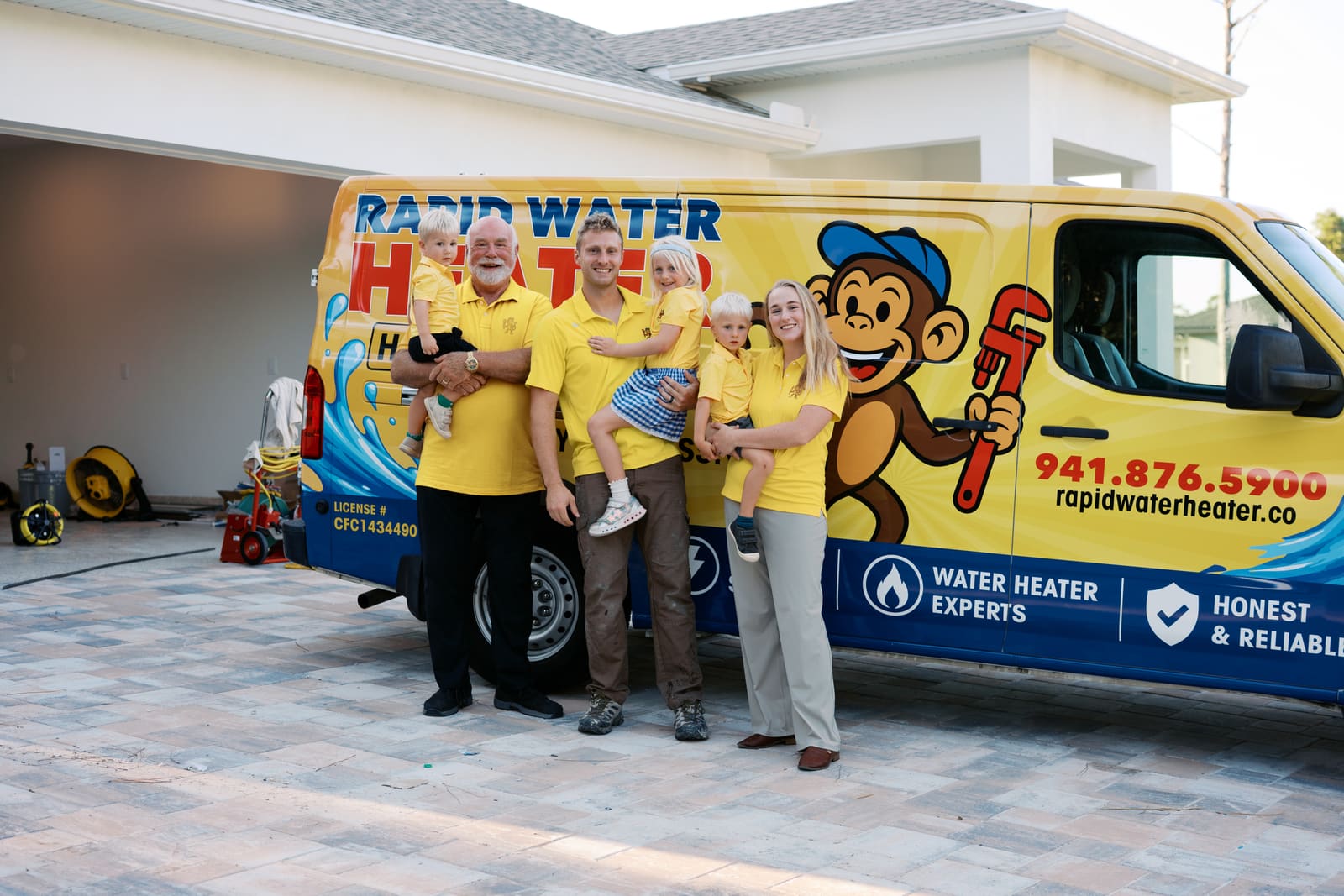 The whole Rapid Water Heater family and team in yellow shirts in front of the company van