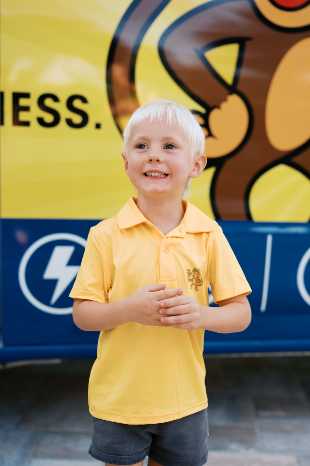 A young boy in a Rapid Water Heater shirt standing in front of the company van